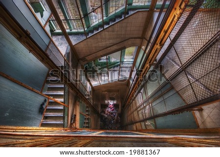 looking down an elevator shaft surrounded by stairs