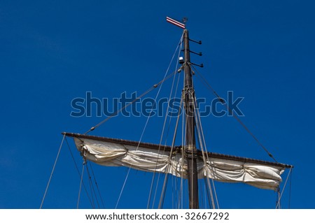 ropes and the upper shortened sail of a big sailing boat