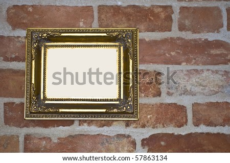 empty old golden frame on a red brick wall