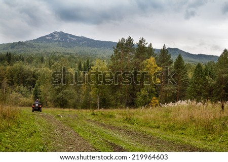 Quad bike rides along the road to the mountains.
