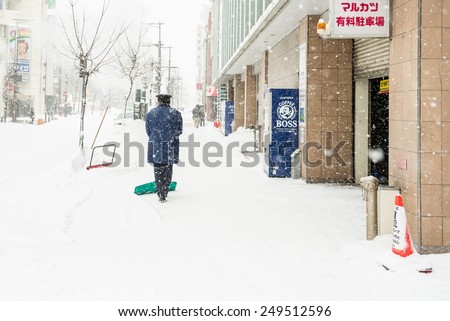 ASAHIKAWA, JAPAN - JANUARY 7, 2015: Man Shoveling on Sidewalk.