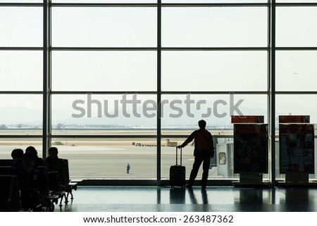 BUSAN, KOREA - MARCH 17, 2015: Man looking out airport window.