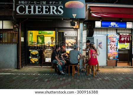 KYOTO, JAPAN - JULY 13, 2015: People with a beer at street restaurant table.
