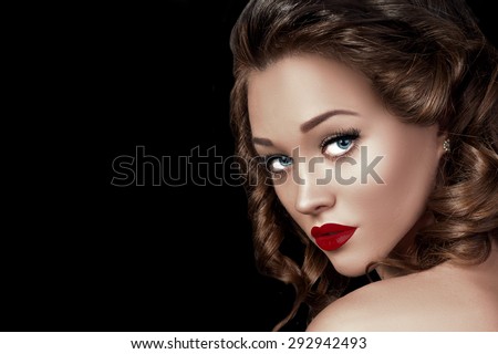 Beauty Fashion Woman Model Face Closeup. Beautiful Professional Make up and Hairstyle. Red Sexy Lips and Long Eyelashes. Gorgeous Glamour Lady Portrait. Isolated on Black Background.