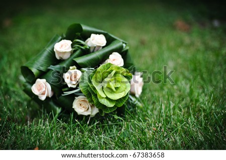 bouquet of decorative cabbages and roses l on green grass closeup