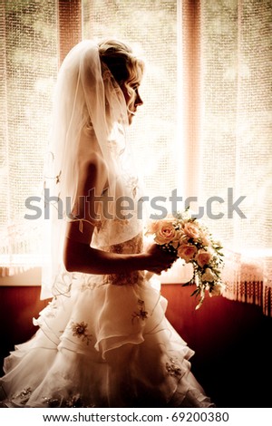 silhouette of the bride weared in dress and veil with a bouquet