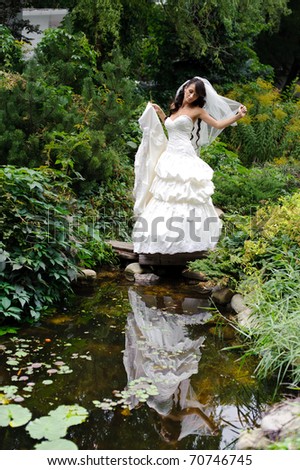 beautiful girl in wedding dress with reflection on the water
