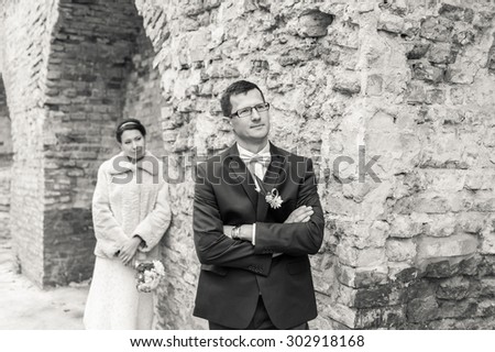 black and white photo of bride and groom on the background of ancient brick wall