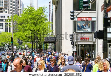 CHICAGO, USA - MAY 24, 2014: A crowded shopping street with lots of pedestrians, some green trees and Retail-Shops.
