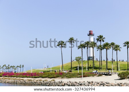 LONG BEACH, USA - JUNE 7, 2014: The Lions Lighthouse for Sight in Shoreline Aquatic Park. In the base the harbor masters office is located. In the park there are people walking, biking.