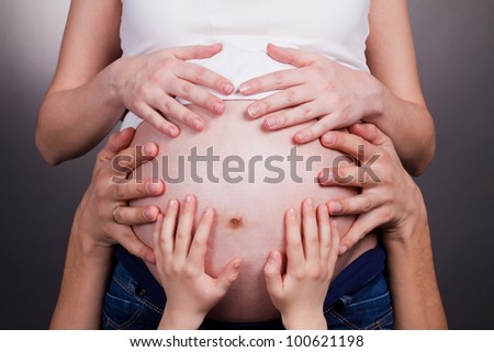 family hands holding tummy closeup
