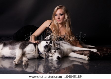 portrait of young blond woman with dogs (siberian husky breed)