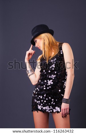 blond hair beautiful woman in black sequin dress on black background