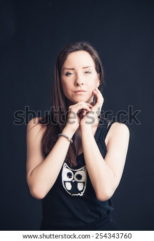 Pretty young woman in black t-shirt over studio background