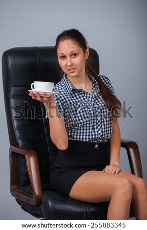 Business woman sitting on a chair with cup of tea.