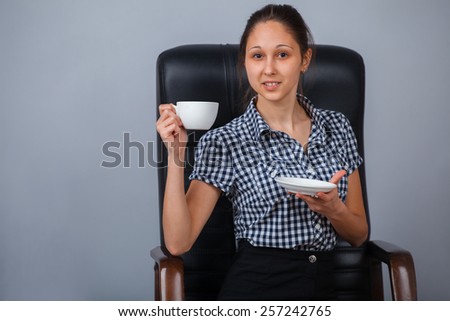 Business woman sitting on a chair with cup of tea.