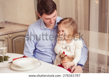 Happy father and cute little daughter at the festive holiday table