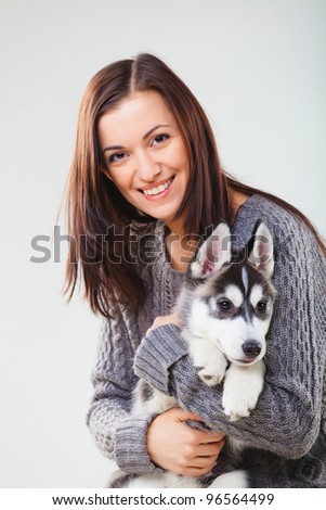 young woman with siberian husky puppy