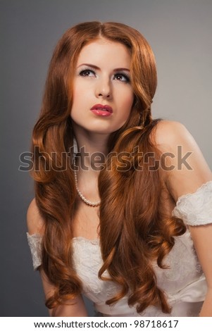 beautiful bride with curly red hair in wedding dress