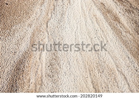 Sand surface after the rain with the visible traces of the raindrops and water currents