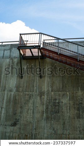 Metal stairs on the gray concrete wall.