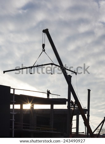 Construction of the new building. The crane working. Silhouette.