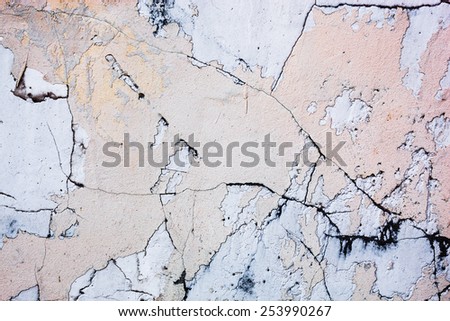 Cracked concrete surface with the remains of sandy-tan paint