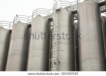 Metal tower silos (for storing bulk materials) of the industrial plant.