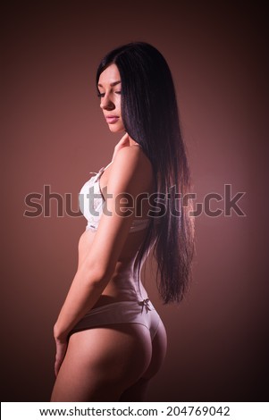 elegant buns: gorgeous sexy lady black hair glamor pinup girl with excellent fitness bum happy posing relaxing standing half back to camera & looking down shy on copy space background portrait image