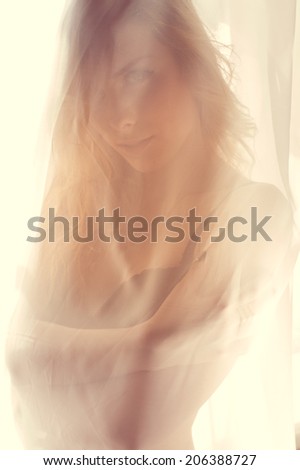 closeup portrait of blond pretty lady having fun hiding in bikini or undies happy smiling & relaxing looking at camera on window light copy space