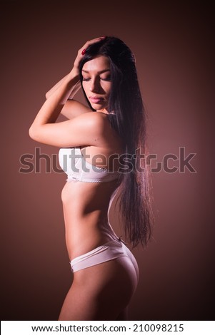 elegant buttocks: portrait of gorgeous lady black hair glamor pinup girl with excellent fitness bum happy posing in bikini or undies relaxing standing on copy space background
