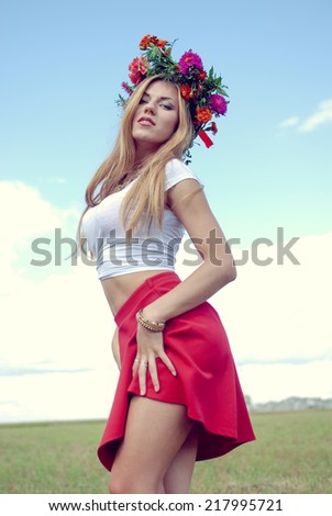 summer dancing series: portrait of sensual blonde young pretty lady wearing flower crown having fun enjoying herself & looking at camera on summer outdoors copy space background