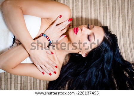 sleeping beauty: portrait of eyes closed beautiful sexy young lady having fun sensually looking at camera lying on bed