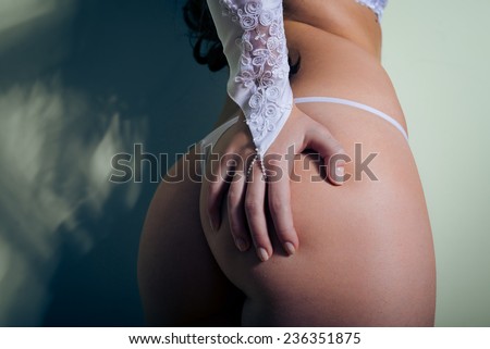Perfect sexy buttocks of pretty woman in white lingerie with hand on bum close-up picture