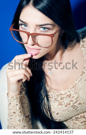 closeup portrait of young pretty lady in glasses relaxing sitting on chair & flirty looking at camera
