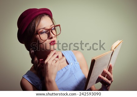 Girl in a red hat and glasses reading a book