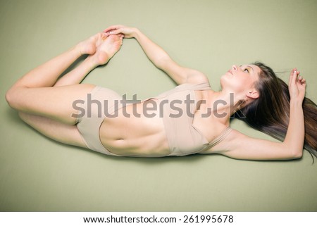 Portrait of beautiful sexy young lady with perfect fit body in flying shape on gray copy space background