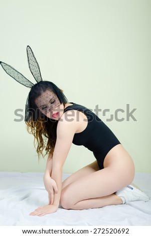 Portrait of sexy mysterious young pretty lady in bunny ears mask relaxing in bed