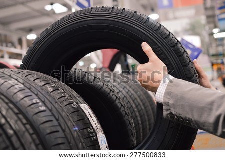 Picture closeup on hands choosing a tire or tyre