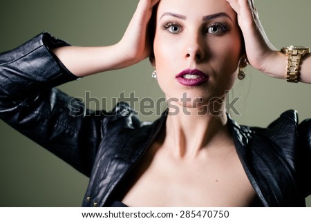 Hot sexy pretty young lady wearing leather jacket sensually looking at camera on grey copyspace background, picture closeup