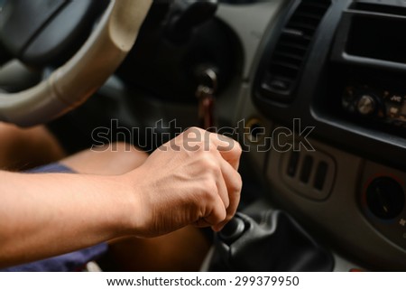 driver\'s right hand shifting the gear stick in car, close up image