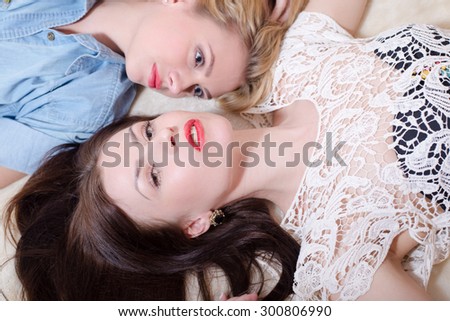 2 sexy pretty best girl friends with red lipstick having fun relaxing in bed head to head