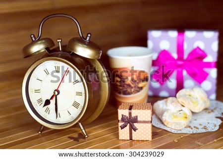 A coffee, two pastries, two present boxes and retro alarm clock