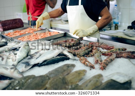 Picture of store tray with seafood. Closeup of prawns, shrimps and fish on market indoor background.