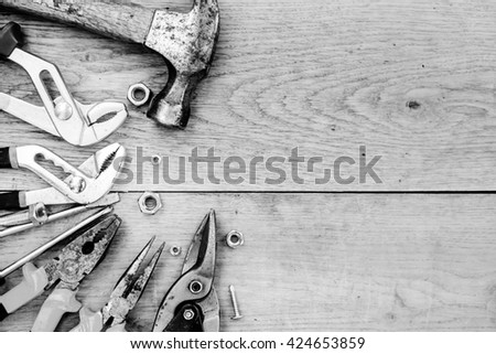 Black and white photography of toolkit with hammer, set of wrenches over wooden background copyspace