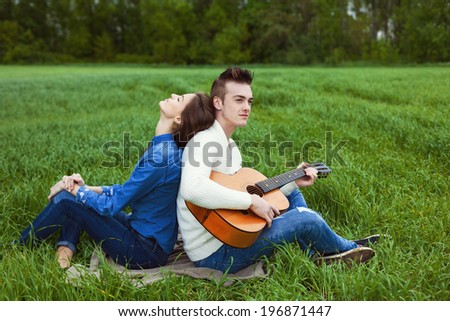 young guy playing guitar for his girlfriend