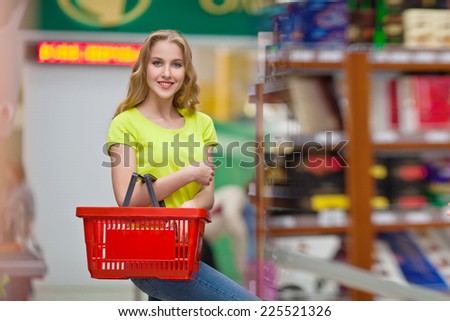 Beautiful girl with a basket in the hands of merchandised at the grocery store