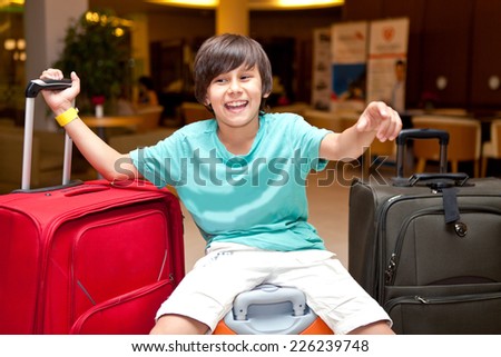 Boy sitting with suitcases and bags in the room. journey