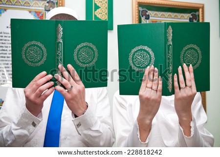 Man and woman holding hands in the Holy Quran and cover their own face