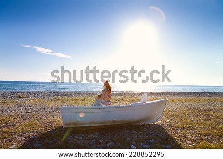 Mom and son on the sea shore in a boat summer day